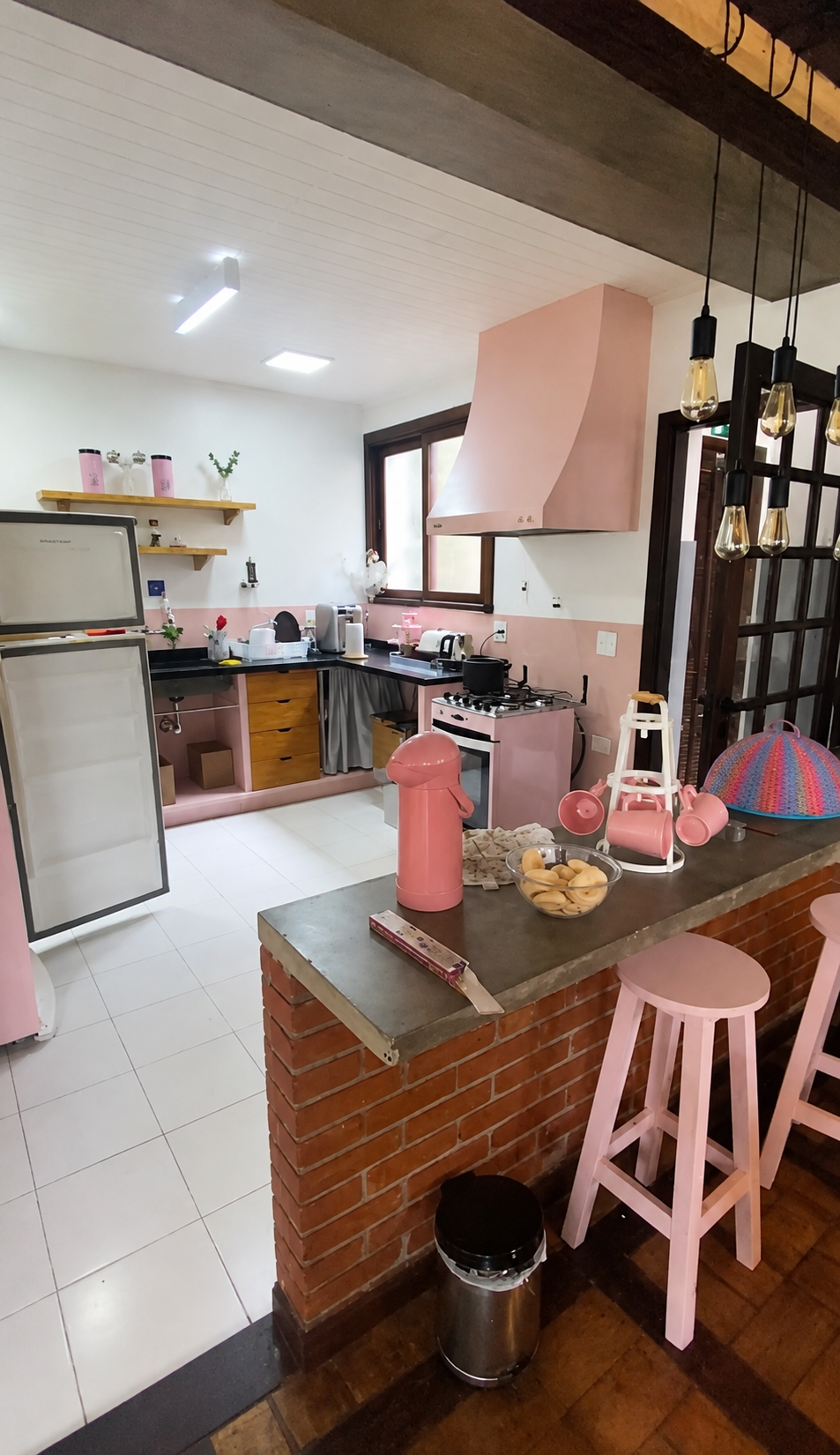 Cozinha rosa da Casa Magdala com bancada e banquetas